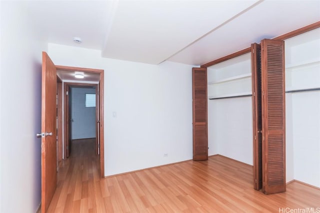 unfurnished bedroom with a closet and light hardwood / wood-style floors