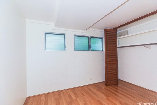 unfurnished bedroom with wood-type flooring and ornamental molding