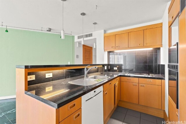 kitchen featuring dishwasher, sink, hanging light fixtures, tasteful backsplash, and black oven