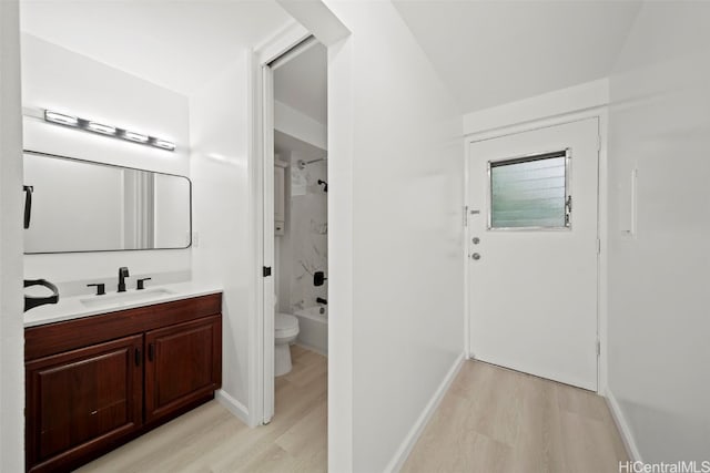 full bathroom with hardwood / wood-style flooring, tiled shower / bath combo, toilet, and vanity