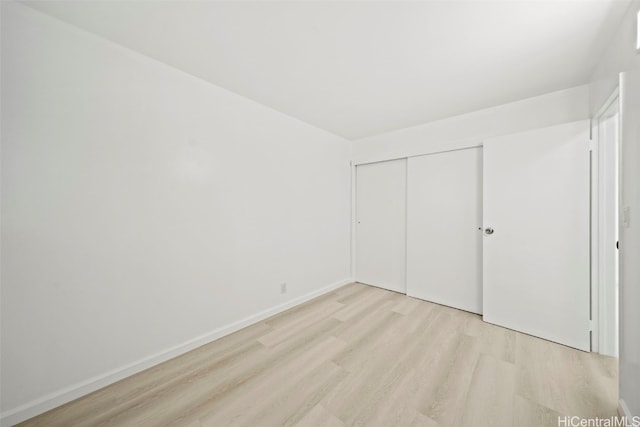 unfurnished bedroom with light hardwood / wood-style floors and a closet