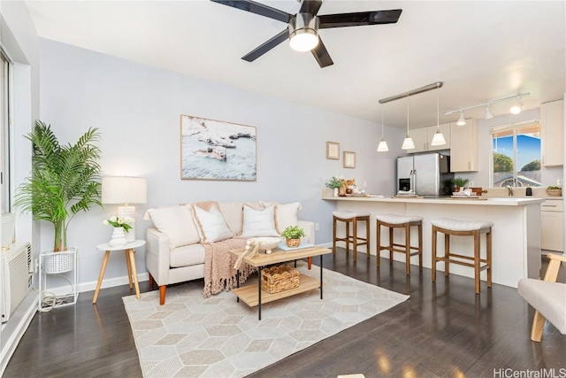 living room with dark hardwood / wood-style flooring and ceiling fan