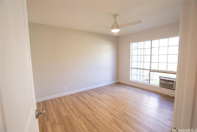 empty room featuring a wall mounted air conditioner, light hardwood / wood-style flooring, ceiling fan, and plenty of natural light