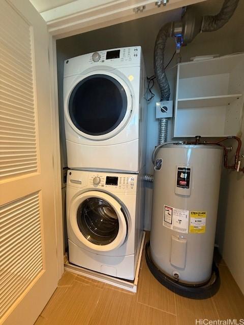 laundry room featuring electric water heater and stacked washer and dryer