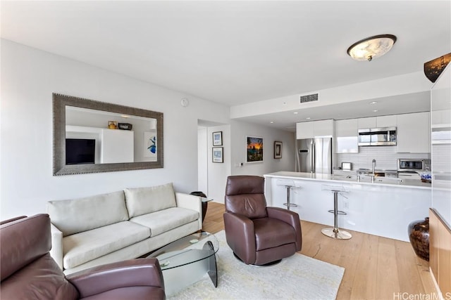 living room featuring light hardwood / wood-style flooring and sink