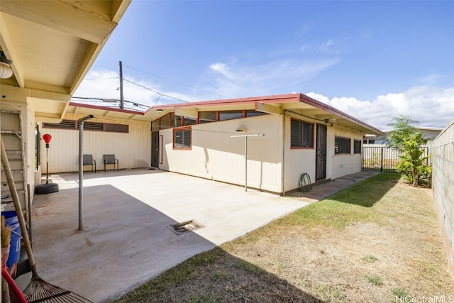 rear view of house with a yard and a patio