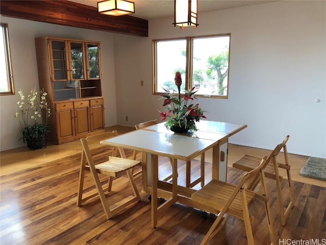 dining space featuring hardwood / wood-style floors and beamed ceiling