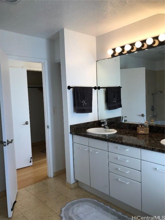 bathroom with tile patterned floors, vanity, and a textured ceiling