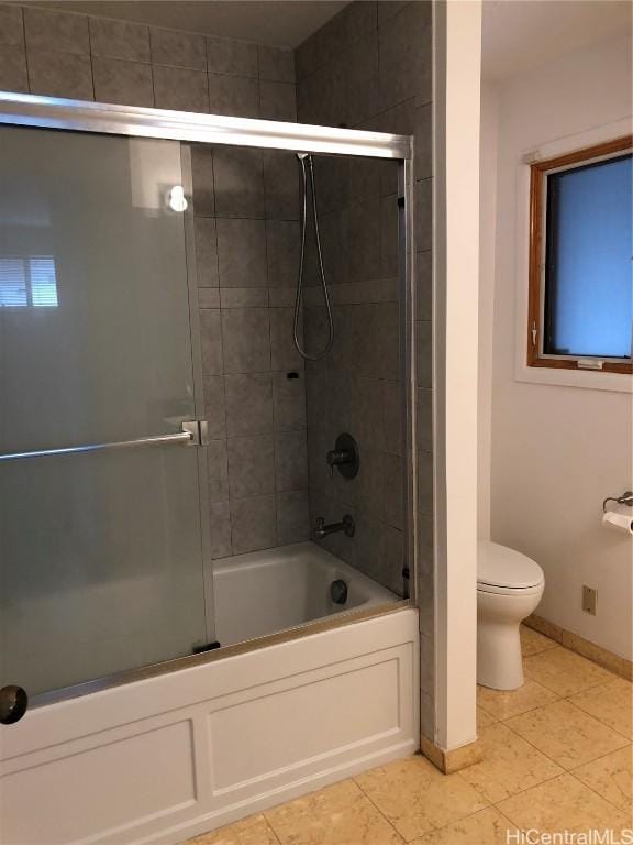 bathroom featuring tile patterned flooring, toilet, and enclosed tub / shower combo