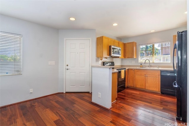 kitchen featuring sink, dark hardwood / wood-style floors, and black appliances