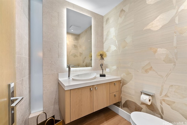 bathroom with wood-type flooring, vanity, and toilet