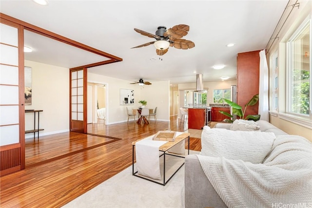 living room with ceiling fan, french doors, and light hardwood / wood-style floors