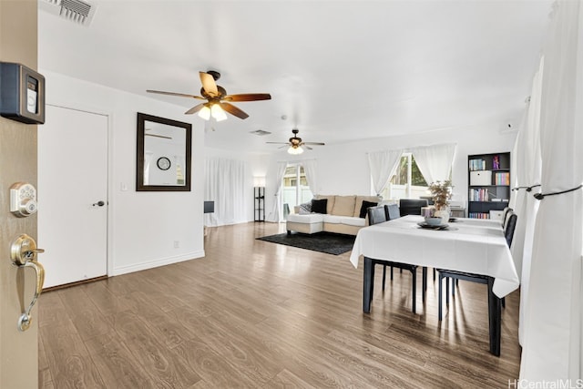 dining space with ceiling fan and hardwood / wood-style flooring