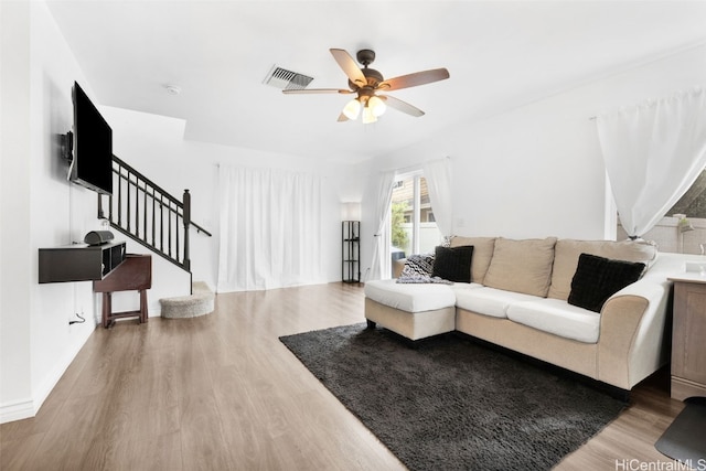 living room featuring ceiling fan and hardwood / wood-style floors