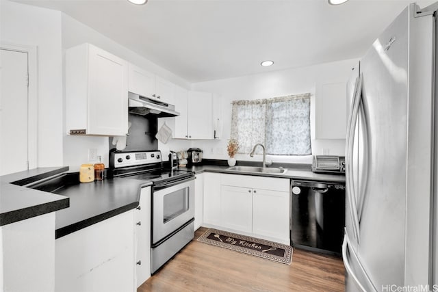 kitchen featuring appliances with stainless steel finishes, light wood-type flooring, white cabinetry, and sink