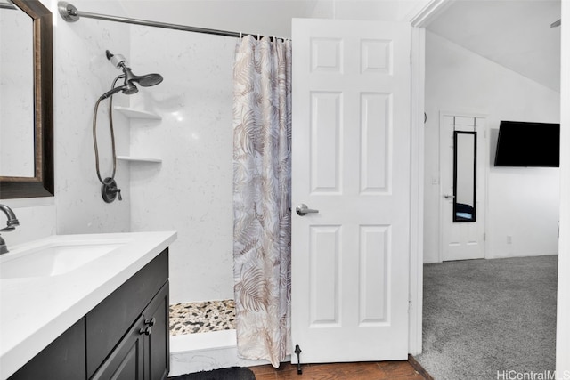 bathroom featuring curtained shower, vanity, and lofted ceiling