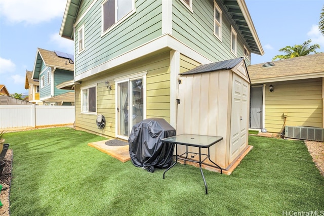 rear view of house with a yard and central AC