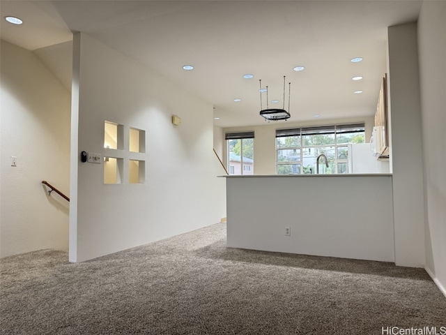 carpeted spare room with sink and lofted ceiling