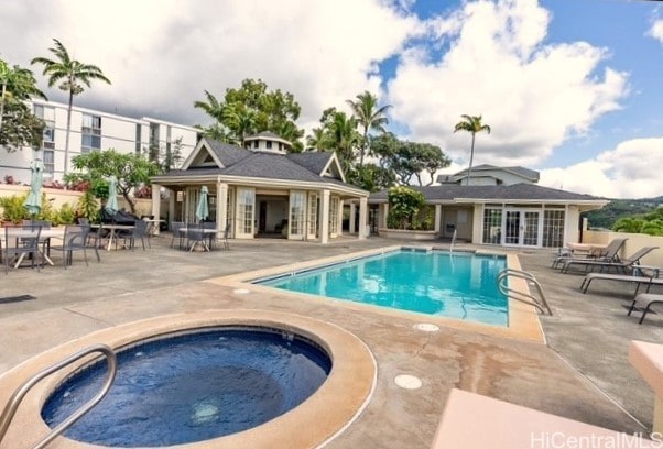 view of pool featuring a hot tub and a patio area