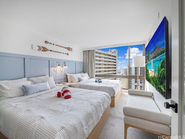 carpeted bedroom with a wall of windows