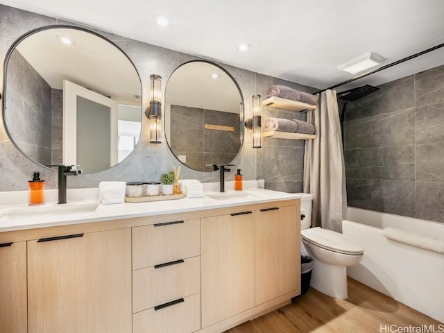 full bathroom with vanity, toilet, shower / bath combo with shower curtain, tile walls, and wood-type flooring