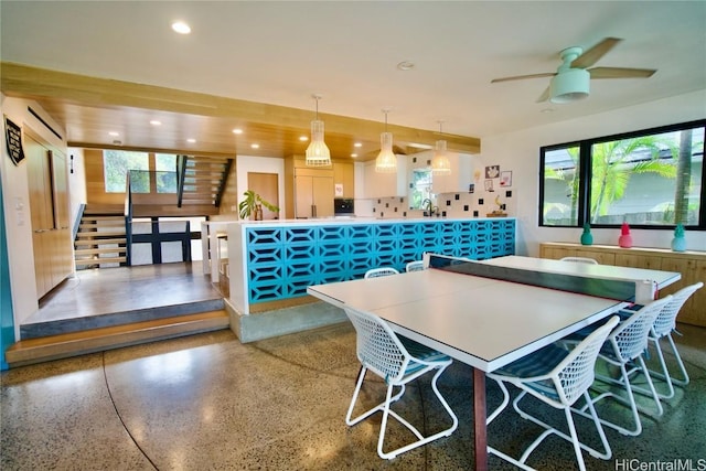 dining space with an AC wall unit and ceiling fan