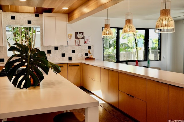 kitchen featuring backsplash, hanging light fixtures, light countertops, a peninsula, and recessed lighting