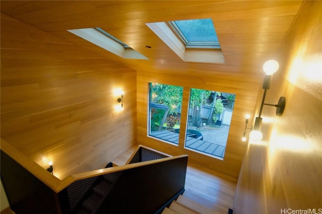 home theater with a skylight and wooden walls