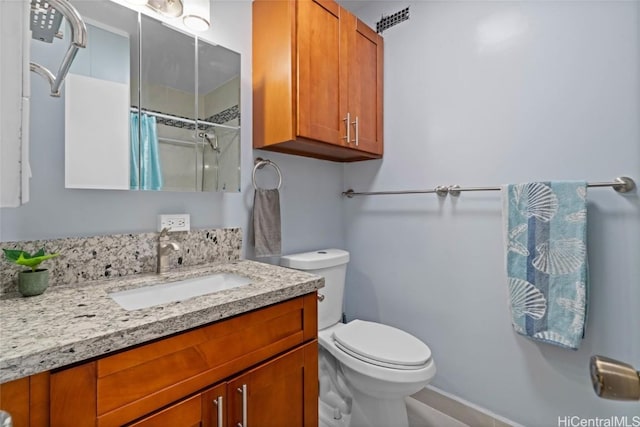 bathroom with walk in shower, vanity, and toilet