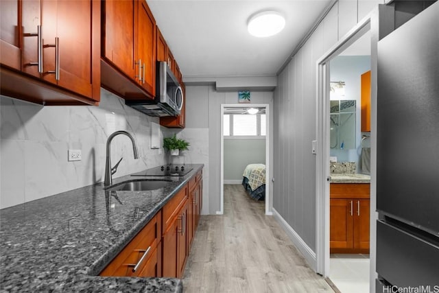 kitchen featuring light hardwood / wood-style floors, sink, and dark stone countertops