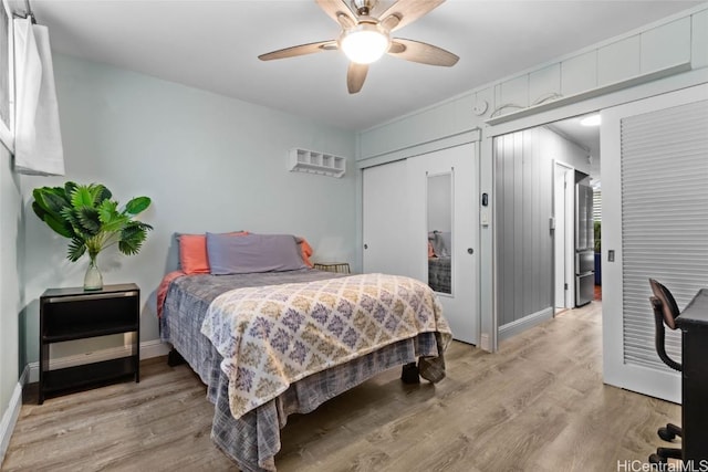 bedroom with ceiling fan, light hardwood / wood-style floors, and a closet