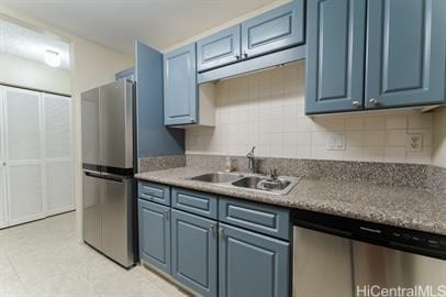 kitchen with decorative backsplash, sink, blue cabinetry, and appliances with stainless steel finishes