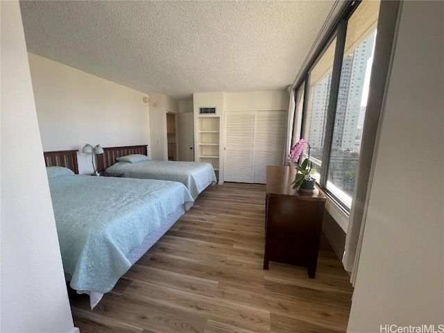 bedroom with a textured ceiling and hardwood / wood-style flooring