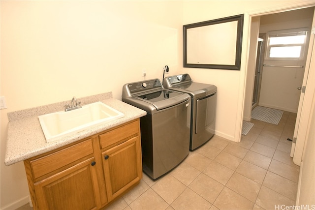 laundry room with cabinets, sink, light tile patterned flooring, and washer and dryer