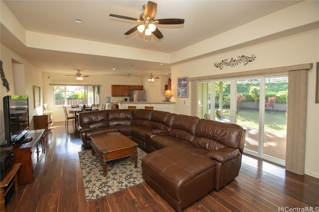 living room with ceiling fan and dark wood-type flooring