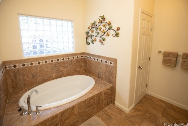 bathroom featuring tile patterned flooring and a relaxing tiled tub