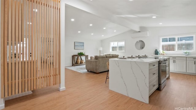 kitchen with white cabinets, a breakfast bar area, a wall mounted AC, a kitchen island, and lofted ceiling with beams