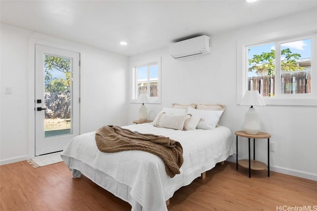 bedroom featuring light hardwood / wood-style flooring and an AC wall unit