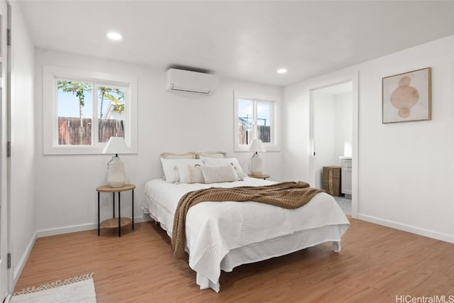 bedroom with an AC wall unit and hardwood / wood-style floors