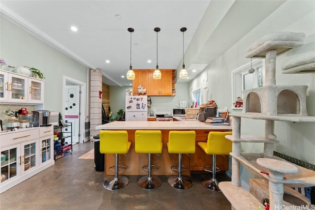 kitchen with white fridge, a kitchen bar, and hanging light fixtures