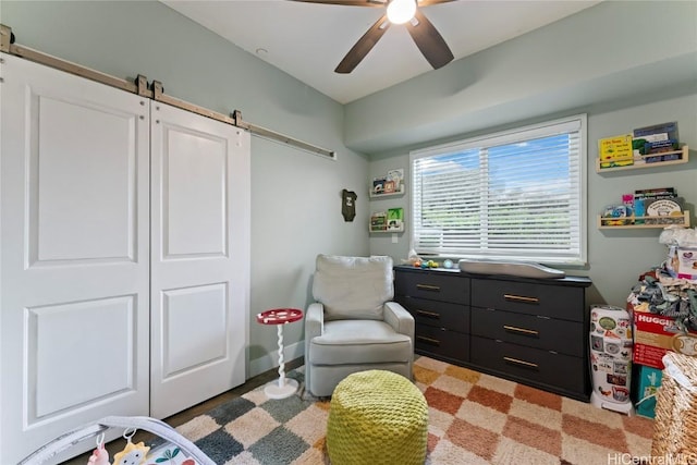 bedroom with a barn door, a closet, and ceiling fan