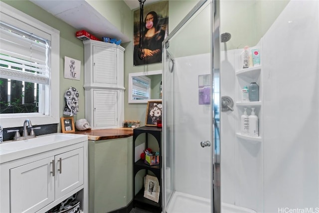 bathroom featuring vanity and a shower with door