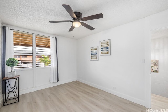 unfurnished room with ceiling fan, a textured ceiling, and light wood-type flooring