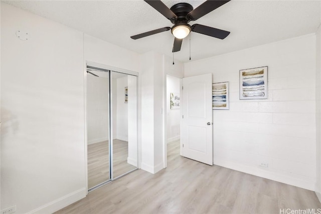 unfurnished bedroom featuring light wood-type flooring, a closet, and ceiling fan