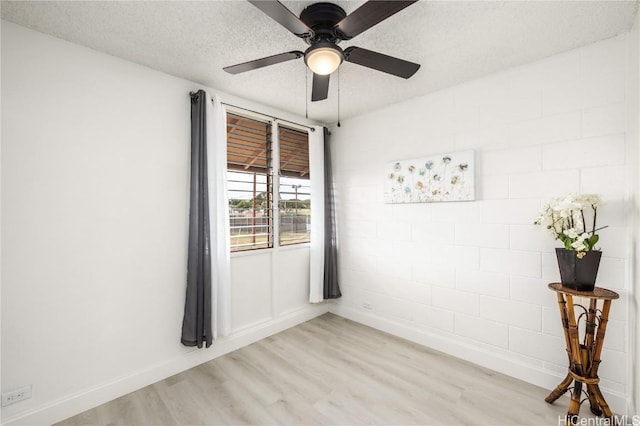 unfurnished room with ceiling fan, light hardwood / wood-style floors, and a textured ceiling