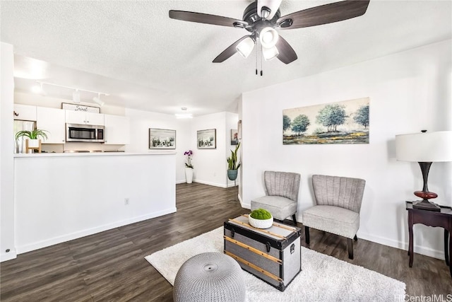 living room with ceiling fan, dark hardwood / wood-style flooring, and a textured ceiling