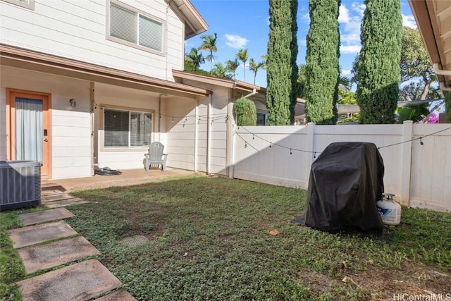 view of yard featuring fence and central AC