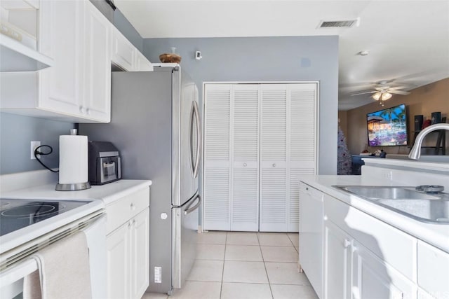 kitchen with light tile patterned floors, white cabinetry, light countertops, and a sink