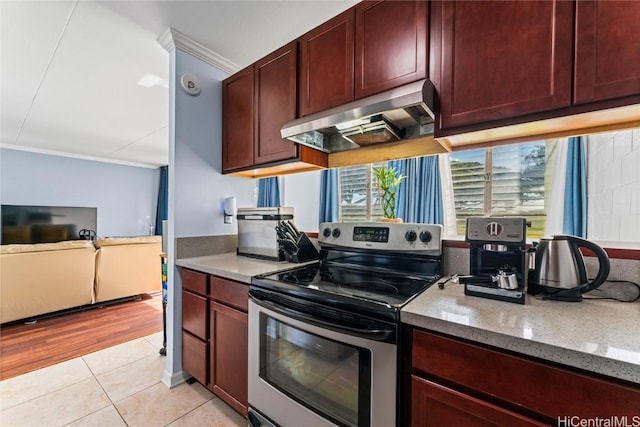 kitchen with electric range, dark stone counters, light tile patterned floors, exhaust hood, and ornamental molding