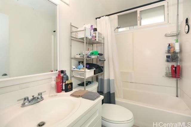 full bathroom with toilet, vanity, and shower / tub combo with curtain